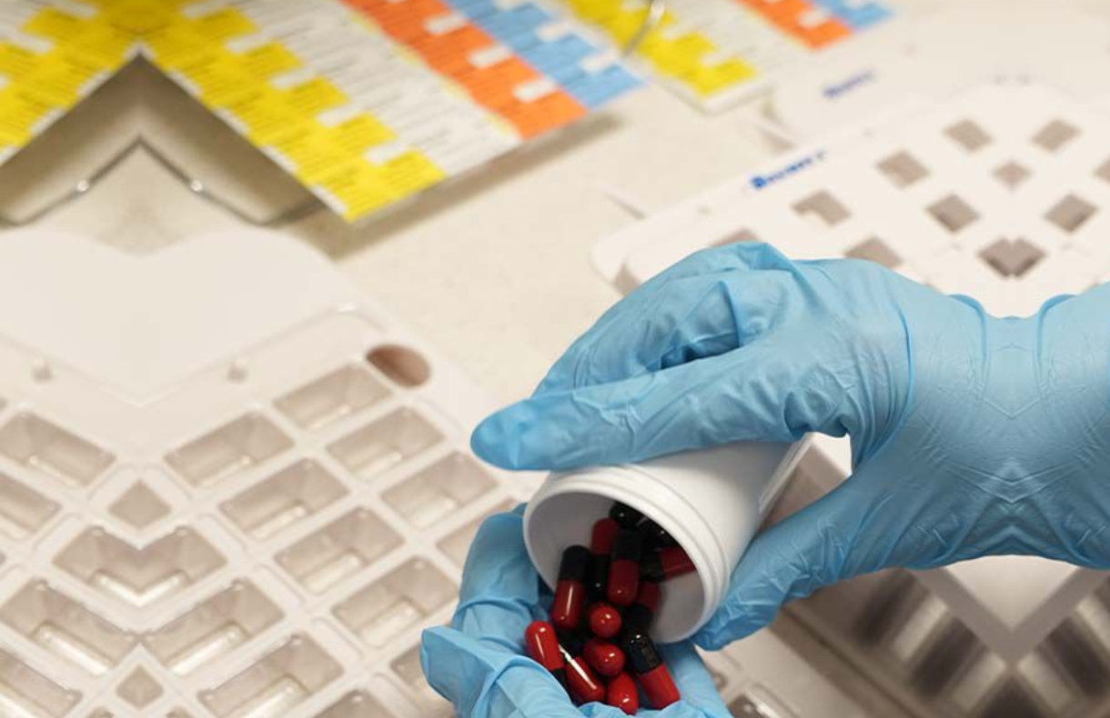 blue glove with medicines on a cup