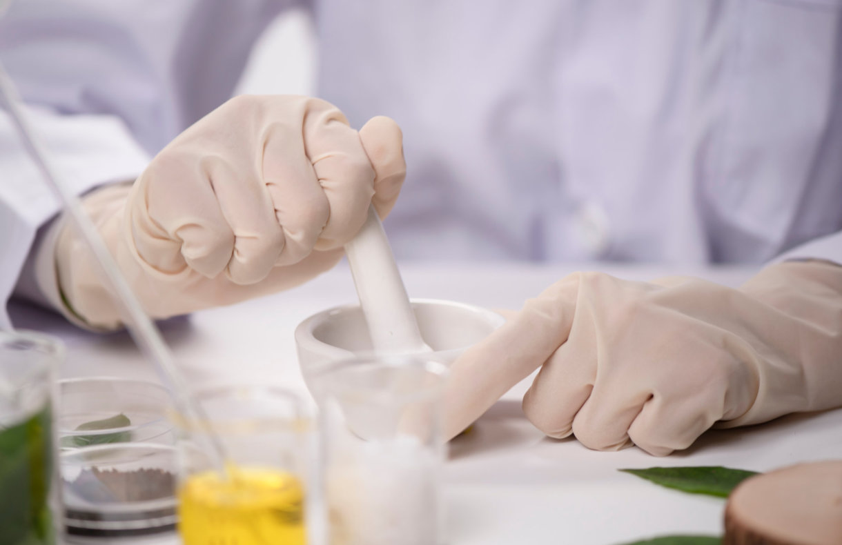 hands with glove while compounding a medicine