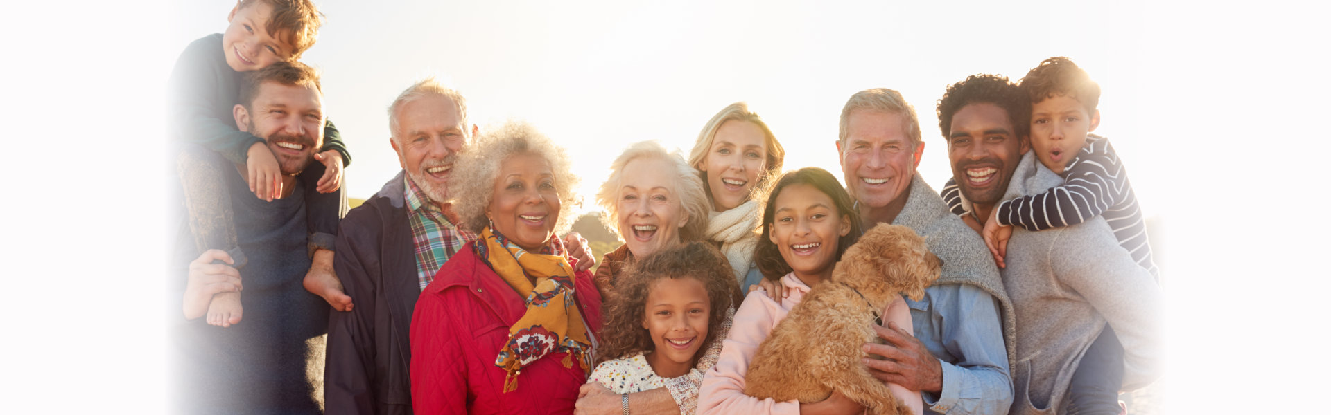 Portrait Of Multi-Generation Family Group With Dog On Winter Beach Vacation